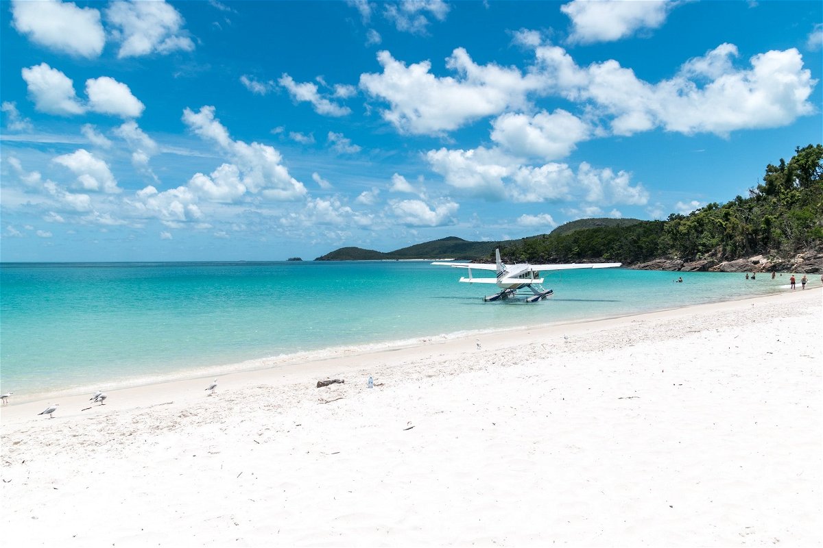 A catamaran on a beach with pristine white sand and blue water