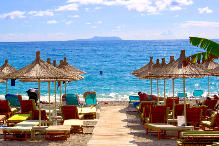Sun beds and Umbrellas looking across the ocean at a beach resort along the Albanian Riviera