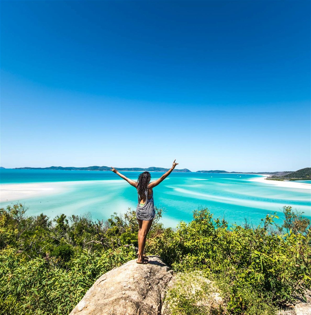 Traveller posing at Whitehaven Beach in Australia