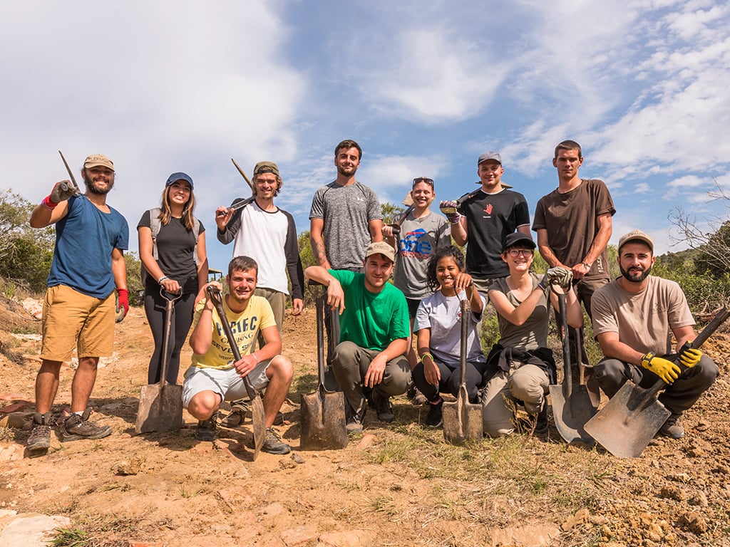 A group of travellers holiding shovels and picks