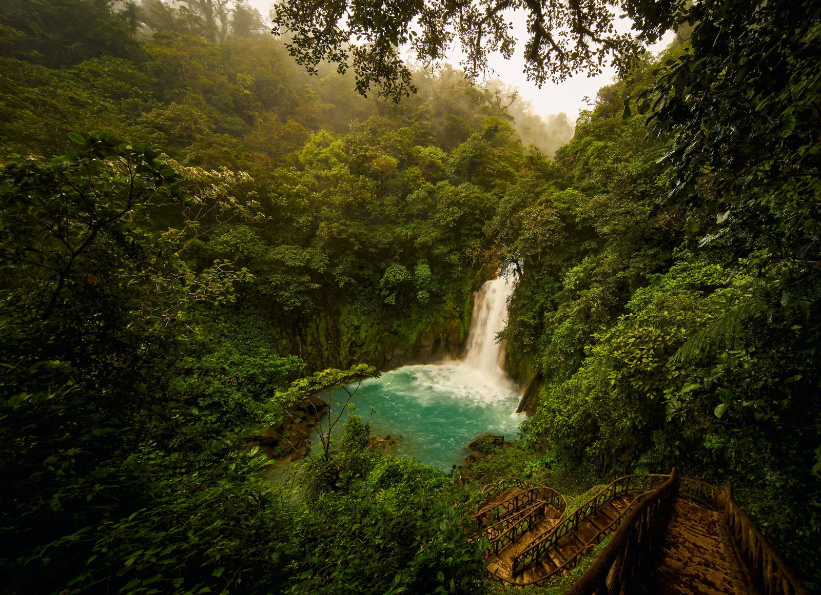 A waterfall in the middle of a lush green forst in Costa Rica